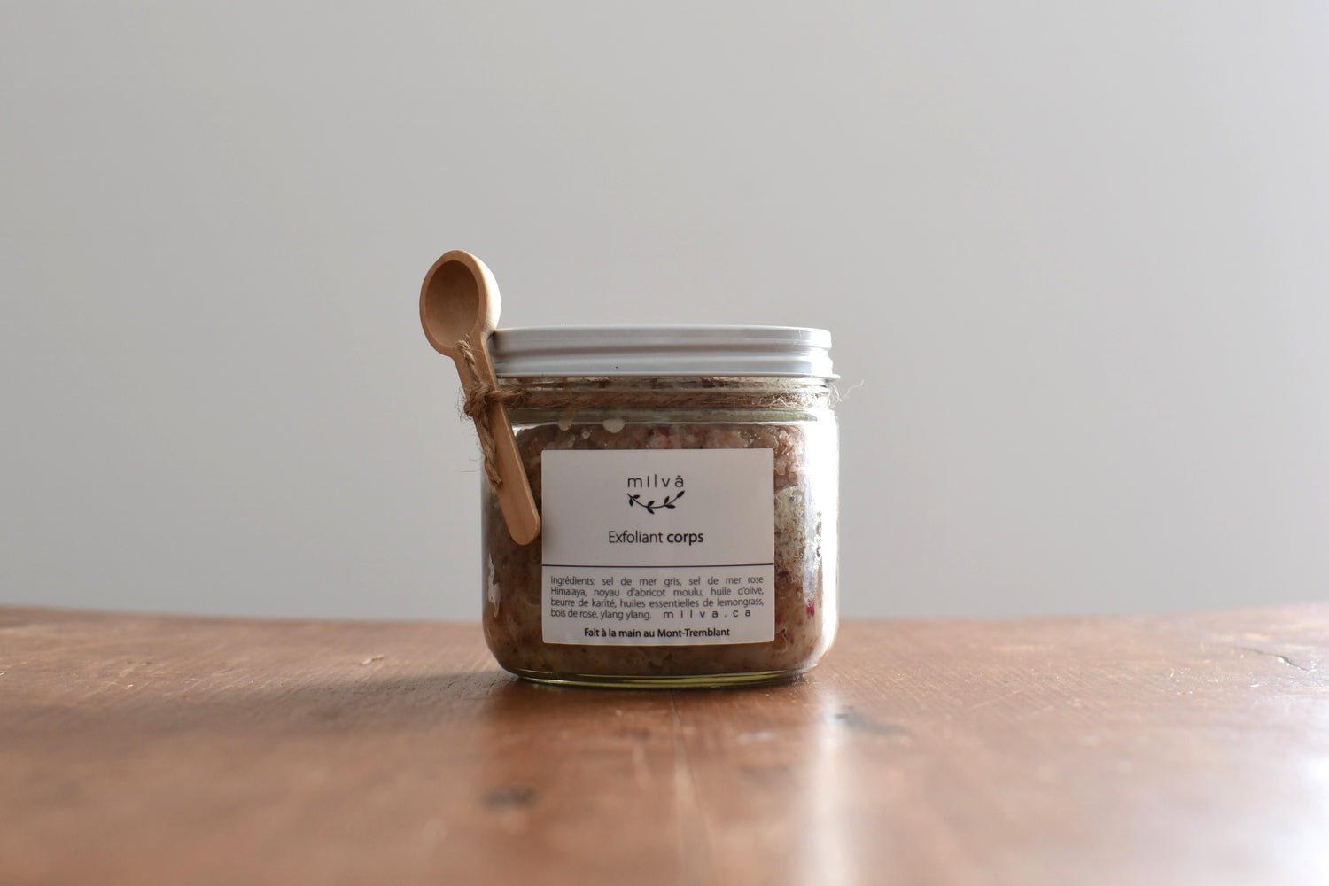 exfoliant pour le corps dans un pot en verre avec une cuillère en bois